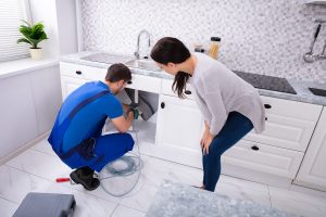 bigstock-Woman-Looking-At-Male-Plumber-284038597