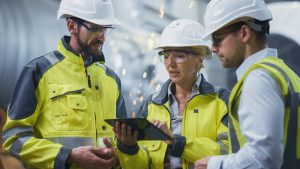 Three,Heavy,Industry,Engineers,Stand,In,Pipe,Manufacturing,Factory,,Use